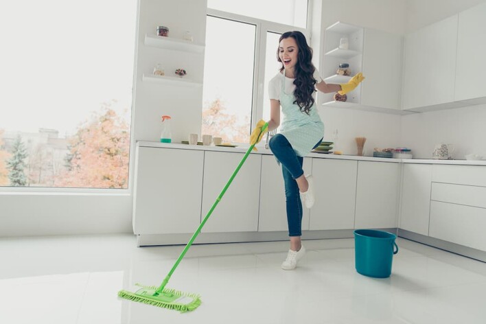 Woman mopping while listening to music 