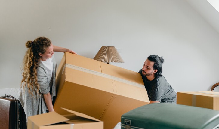 a couple lifting moving boxes