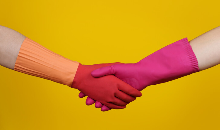 cleaner shaking hands with pink, orange gloves
