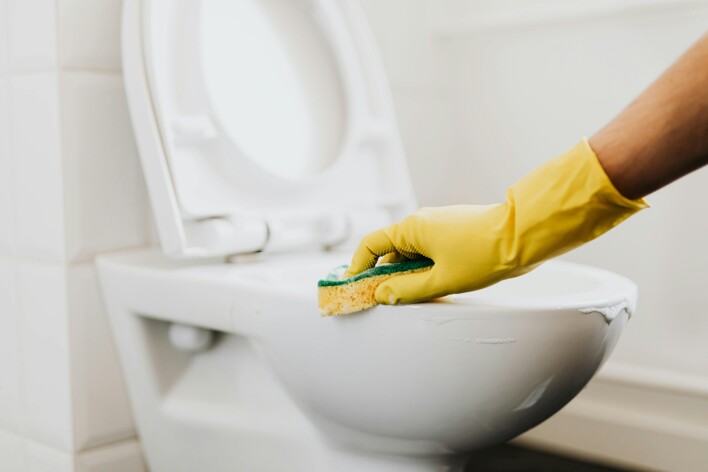 Eine Person putzt die Toilette: eine besondere Aufgabe der Haushaltshilfe
