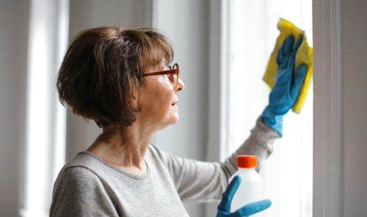 Eine Putzhilfe reinigt die Fenster