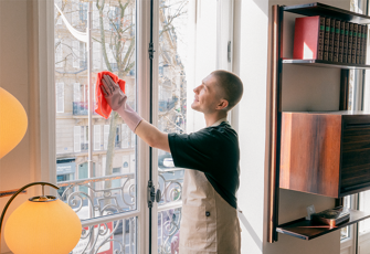 Regelmässige Reinigung - Reinigungskraft wischt Fenster sauber