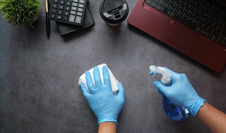 cleaner cleaning the work desk